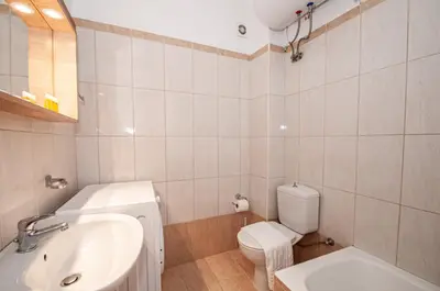 a white bathroom with a sink and a toilet at New Town Apartments in Rhodes Town