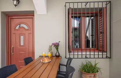 a dining room with a wooden table and a red door at New Town Apartments in Rhodes Town