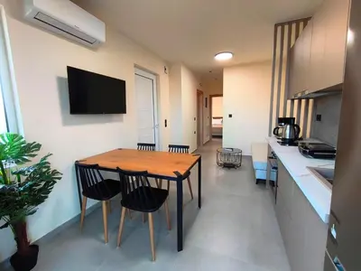 a kitchen with a wooden table and chairs in a room at Villa Maroula in Afantou