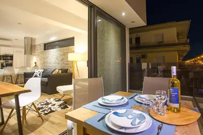 a dining room table with a bottle of wine on it at Yianna's Flat in Faliraki