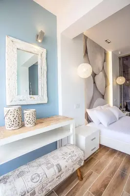 a bedroom with a white bed and a mirror at Yianna's Flat in Faliraki
