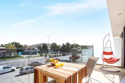 a table on a balcony with a view of a street at Yianna's Flat in Faliraki