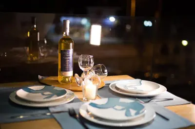 a table with plates and glasses and a bottle of wine at Yianna's Flat in Faliraki