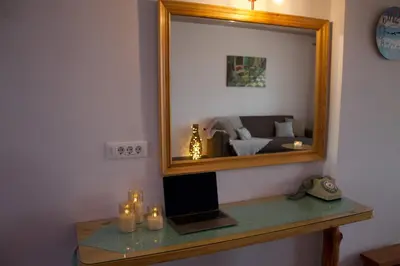 a mirror on a table with a laptop and candles at Seascape Apartment with Private Balcony in Faliraki in Faliraki