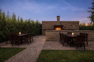 a patio with tables and chairs and a fireplace at Maritina Apartments in Ixia