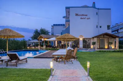 a hotel with a table and chairs next to a pool at Maritina Apartments in Ixia