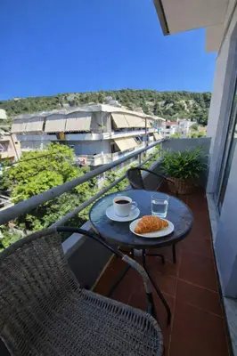 a table with a cup of coffee on a balcony at Maritina Apartments in Ixia