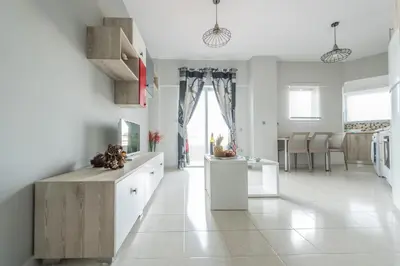a kitchen with white cabinets and a large window at Maritina Apartments in Ixia
