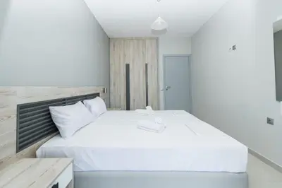 a bedroom with a large white bed with a wooden headboard at Maritina Apartments in Ixia
