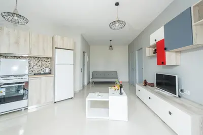 a kitchen with white cabinets and a table in a room at Maritina Apartments in Ixia
