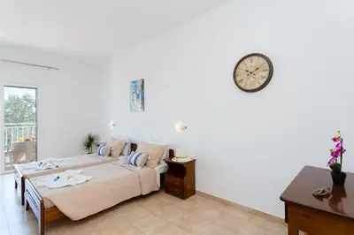 a bedroom with a bed and a clock on the wall at Stelios studios in Archangelos