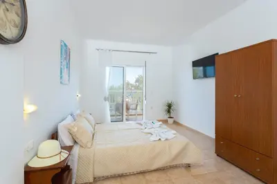 a bedroom with a bed with a clock on the wall at Stelios studios in Archangelos