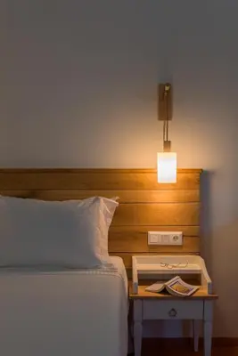 a bed with a wooden headboard and a nightstand next to a bed at Asymi Residences in Symi
