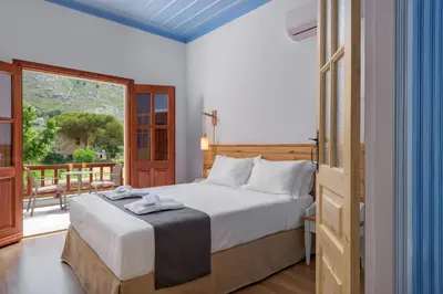a bedroom with a bed and a large window at Asymi Residences in Symi