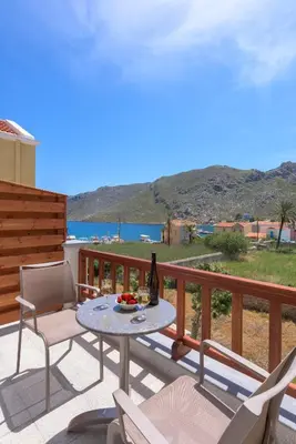 a table and chairs on a balcony with a view of the ocean at Asymi Residences in Symi