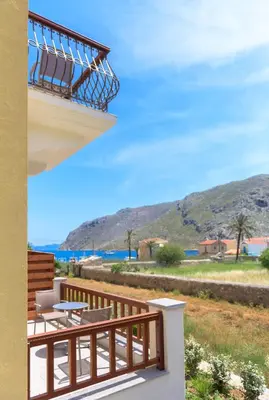a balcony with chairs and a view of the ocean at Asymi Residences in Symi