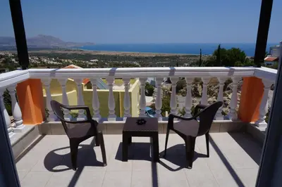 a balcony with two chairs and a table on it at Rhodes Demetrius Luxury Private Villa in Kalathos