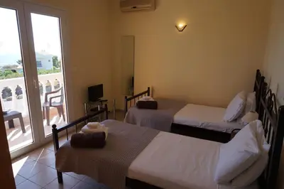 a hotel room with two beds and a balcony at Rhodes Demetrius Luxury Private Villa in Kalathos
