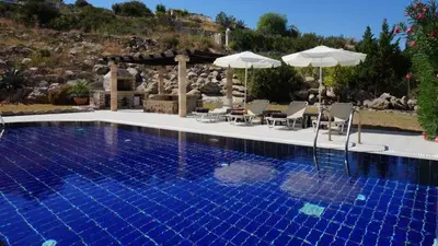 a swimming pool with chairs and umbrellas next to a pool at Rhodes Demetrius Luxury Private Villa in Kalathos