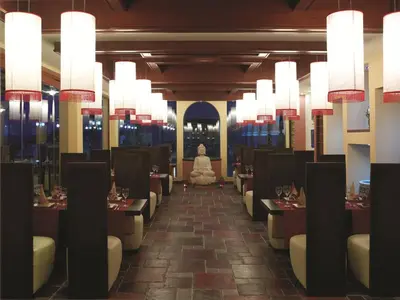 a woman sitting in the middle of a dining room at Atrium Prestige Thalasso Spa Resort & Villas in Lachania
