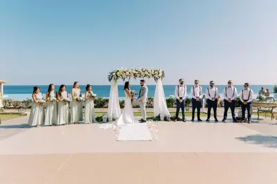 a group of people standing under a wedding arch at Atrium Prestige Thalasso Spa Resort & Villas in Lachania