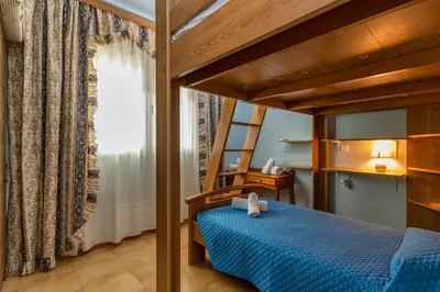 a bedroom with a blue bed and a ladder at Casa d' Acqua in Archangelos