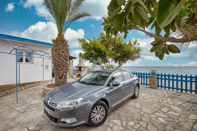 a silver car parked next to the ocean at Casa d' Acqua in Archangelos