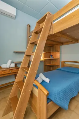 a bunk bed with a ladder in a room at Casa d' Acqua in Archangelos