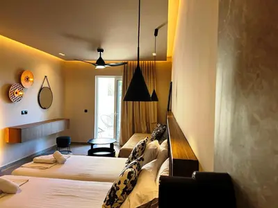 a hotel room with two beds and a table at Argiro Village in Afantou