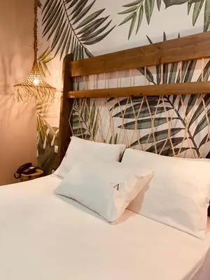 a bedroom with a bed with white pillows and a wall at Argiro Village in Afantou