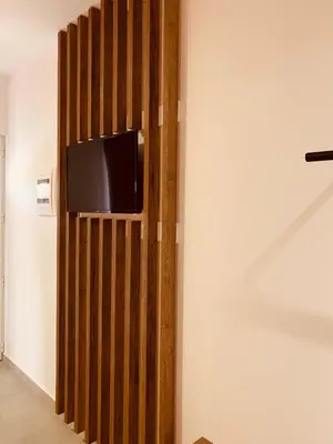a tv on a wooden wall in a room at Argiro Village in Afantou
