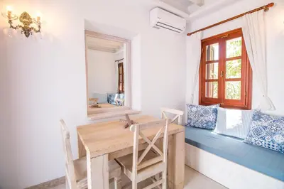 a dining room with a wooden table and a window at Lindian Polis in Líndos