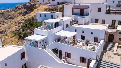 an aerial view of white buildings with the ocean in the background at Lindian Polis in Líndos