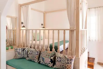 a room with a bed with pillows and a window at Lindian Polis in Líndos