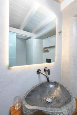 a bathroom with a stone sink and a mirror at Lindian Polis in Líndos