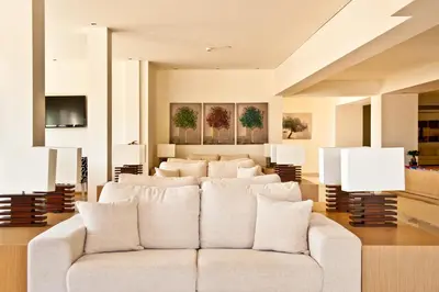 a living room with a white couch and lamps at Lindos White Hotel & Suites in Líndos