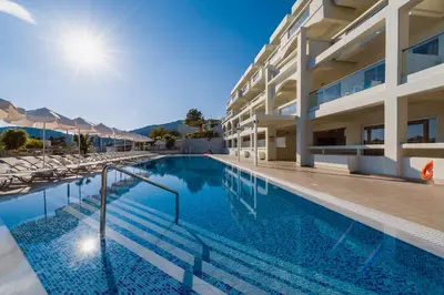 a swimming pool in front of a building at Lindos White Hotel & Suites in Líndos
