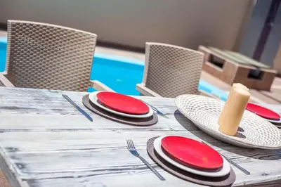 a wooden table with red plates and chairs on it at GM Villa Kallithies Village in Kallithea Rhodes