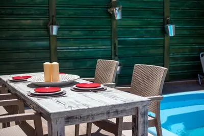 a wooden table with red plates and a candle on it at GM Villa Kallithies Village in Kallithea Rhodes