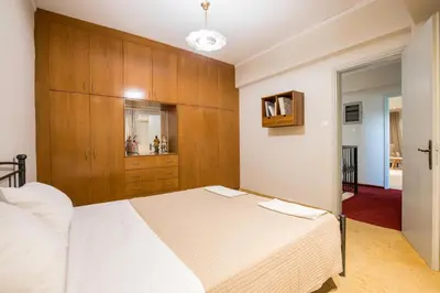 a bedroom with a white bed and wooden cabinets at GM Villa Kallithies Village in Kallithea Rhodes