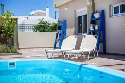 two lounge chairs sitting next to a swimming pool at GM Villa Kallithies Village in Kallithea Rhodes