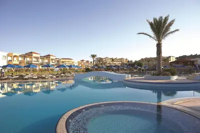 a swimming pool at a resort with a palm tree at Lindos Princess Beach Hotel in Lardos
