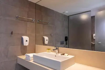 a bathroom with a sink and a mirror at Rodos Princess Beach Hotel in Kiotari