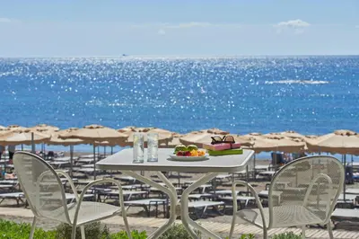 a table with a plate of fruit on the beach at Rodos Princess Beach Hotel in Kiotari