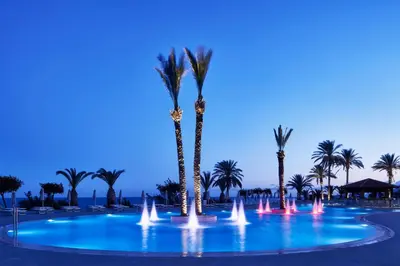 a pool with palm trees and a fountain at Rodos Princess Beach Hotel in Kiotari