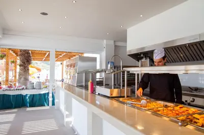 a chef preparing food in a large kitchen at Sun Palace Hotel in Faliraki