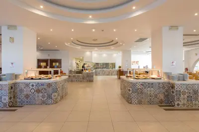a restaurant with tables and counters in a building at Sun Palace Hotel in Faliraki