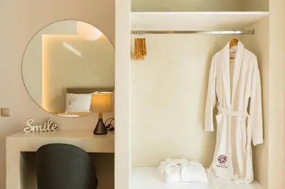 a dressing room with a mirror and a white robe at Villa Dionysus in Gennadi