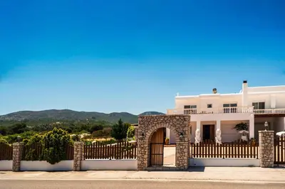a white house with a gate and a fence at Villa Dionysus in Gennadi