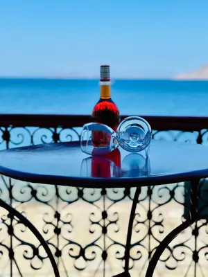 a bottle of wine sitting on a table with a glass at Petridi House in Symi